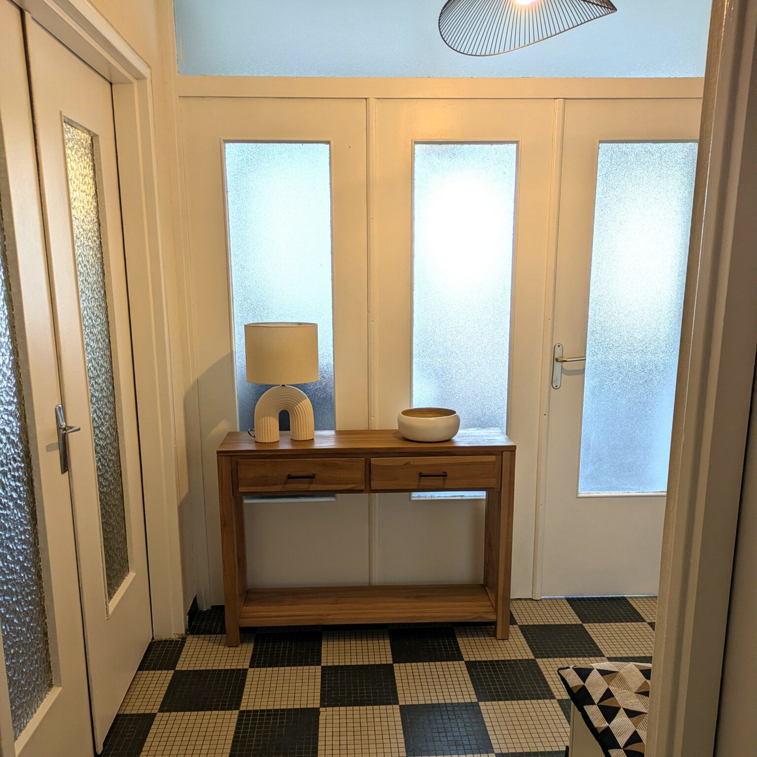 Entrée modernisée après aménagement meuble console bois